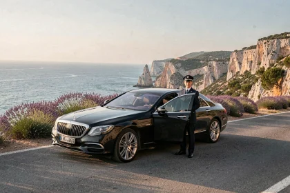 Chauffeur VTC professionnel en Provence-Alpes-Côte d'Azur devant un véhicule haut de gamme avec vue sur la mer Méditerranée