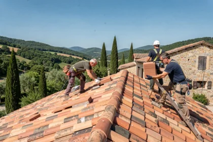 Équipe de couvreurs professionnels travaillant sur une toiture en tuiles traditionnelles dans la Drôme